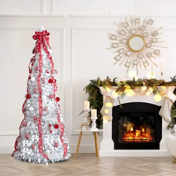 White pre-decorated pop-up Christmas tree with red ribbons next to a fireplace