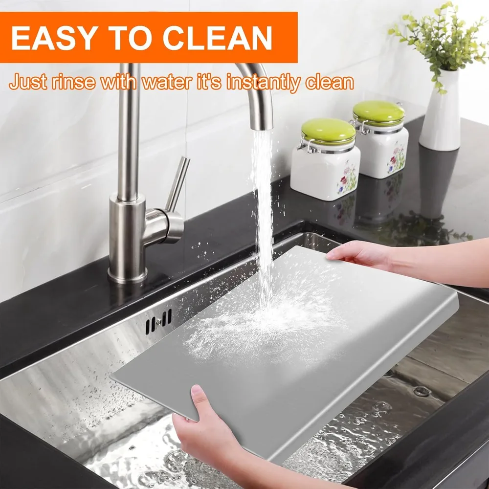 Steel cutting board held over a kitchen sink and rinsed under the tap